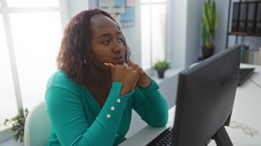 Ofisteki masada yeşil kazak giyen bir kadın.
