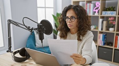 Radyoda mikrofon ve kulaklıkla senaryo okuyan İspanyol kadın.