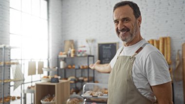 Bir pastanede yakışıklı, yaşlı, İspanyol bir adam, gülümsüyor ve büyük pencereleri ve beyaz tuğlalı duvarları olan rahat bir odada yeni pişmiş malların sergilenişine işaret ediyor..