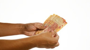 Meksika pesolarını soyutlanmış beyaz arka planda tutan adam.