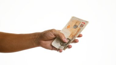 El ele tutuşan İngiliz sterlin banknotları izole edilmiş beyaz bir arkaplan