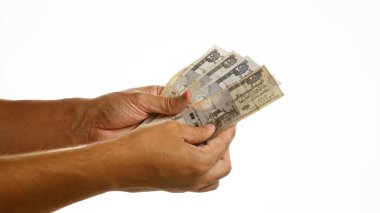 Beyaz arka planda Mısır sterlini tutan adam, Mısır 'da para, finans ve ekonomiyi vurguluyor.