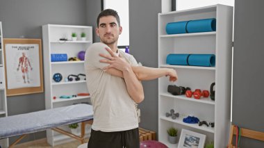 İspanyol adam modern bir rehabilitasyon kliniğinin spor salonunda egzersiz ve sağlık kavramları gösteriyor..