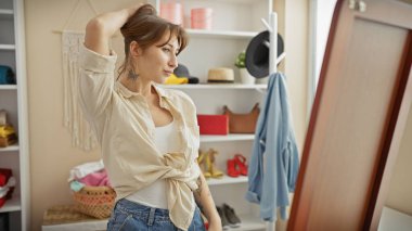 İyi organize edilmiş bir elbise odasında hazırlanan genç bir kadın stili ve iç tasarımı yansıtıyor..