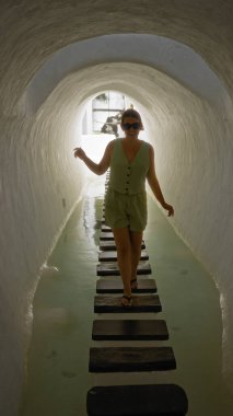 Güneşli bir günde, lagomar, lanzarote ve kanarya adalarında bir tünelde yürüyen genç bir kadın.