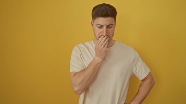 A young hispanic man stands pensively against an isolated yellow background, exuding an attractive and thoughtful demeanor. clipart