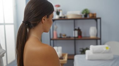 Kaplıca odasında esmer saçlı genç bir kadın. Rahatlatıcı bir iç güzelliği var. Huzurlu bir güzellik ve sükuneti sergiliyor..
