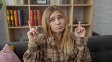 Kafası karışmış, sarı saçlı beyaz bir kadının oturma odasında yukarı bakan bir portresi..