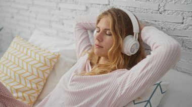 Genç, kadın, dinleniyor, yatakta, dinliyor, dinliyor, müzik dinliyor, kulaklık takıyor, rahat, yatak odasında.