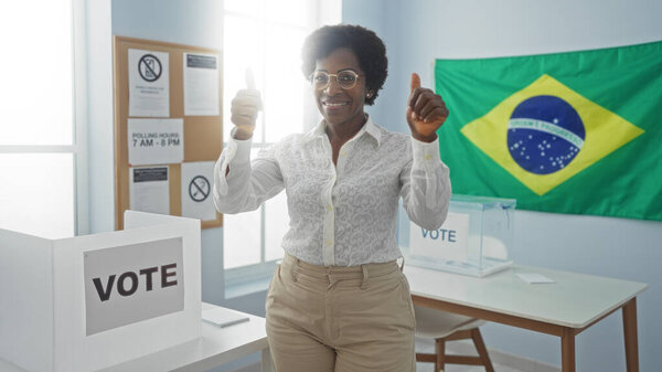 Женщина, голосующая в бразильской избирательной комнате, показывает большие пальцы на фоне кабины для голосования и бразильского флага