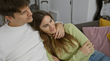 Sıcak, modern bir oturma odasında kucaklaşan sevgi dolu bir çift.