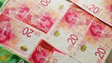 İsrail şekel banknotları tahtadan bir yüzeye saçılmış.