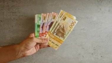 Norveç 'ten gelen para birimini gösteren somut arkaplanlara karşı Norveç Kronu' nun el ele tutuşması