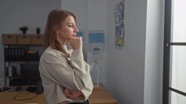 Güzel, sarışın, beyaz bir kadın, kapalı bir ofiste önemli bir şey düşünüyor..