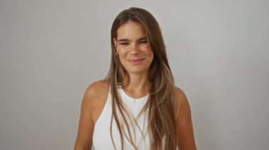 İzole edilmiş, genç, esmer bir kadın gülümsüyor. Çekici, güzel, beyaz arka planda beyaz bluz giyen bir kadın.