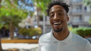 Güneşli bir günde, şehir parkında diş telleriyle gülümseyen Afrikalı genç bir Amerikalı..
