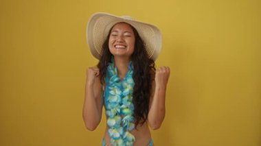 Yaz kutlaması, şapkalı genç Çinli kadın ve başarı ve mutluluk çığlıkları atan Hawaii Lei sarı arka planda heyecanlı kazanan