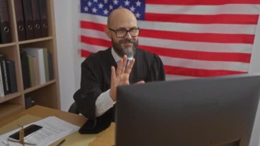 Arka planda Amerikan bayrağı olan bir ofiste çalışan, hukuki belgeleri ve telefonu olan İspanyol bir adam..