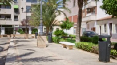 Bulanık ağaçlar, banklar, kaldırımlar, çöp tenekeleri, sokak lambaları ve apartman binaları ile odağını kaybetmiş bir şehir manzarası yaratıyor..