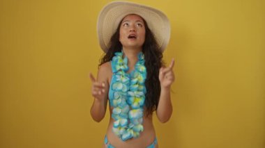 Yazlık şapkalı genç Çinli kadın ve Hawaii zambağı sarı arka planda hayret dolu bir bakış belirtiyor.