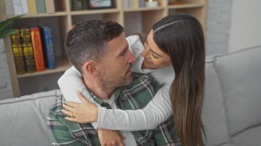 Sevgi dolu bir çift kanepede kucaklaşır, keyifle birlikte, hoş, zevkli bir oturma odasında..