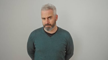 Beyaz bir arka plan karşısında beyaz saçlı, kuşkucu, sakallı bir adam..