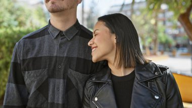 Gülümseyen bir kadın, şehirde bir adama yaslanıyor ve sevgi ve beraberlik yayıyor..