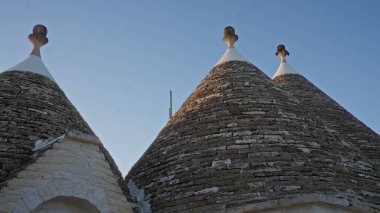 Geleneksel taş evlerin Trulli çatıları Alberobello, Puglia, İtalya 'da berrak gökyüzüne karşı kasabanın eşsiz mimarisini gözler önüne seriyor..