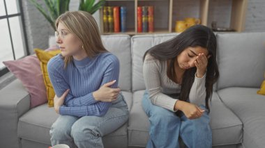 İki kadın, arkadaşlar ya da kız kardeşler, üzgün ve düşünceli görünürler.