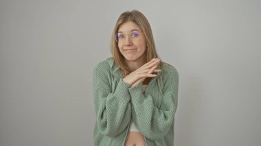 Gözlüklü, yeşil süveter giyen, izole edilmiş beyaz arka plan üzerinde gülümseyen genç bir kadın.