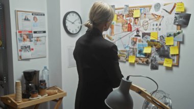 Genç bir kadın dedektif, polis merkezindeki kanıt panosundaki ipuçlarını analiz eder..