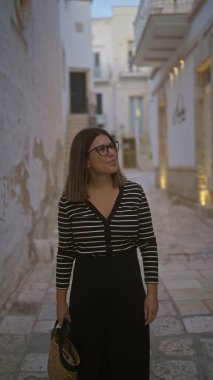 Genç, güzel bir İspanyol kadın polignano 'nun büyüleyici, tarihi sokaklarını keşfediyor. Puglia, İtalya' da bir kısrak. Bu güzel Avrupa manzarasında huzurlu bir anın tadını çıkarıyor..