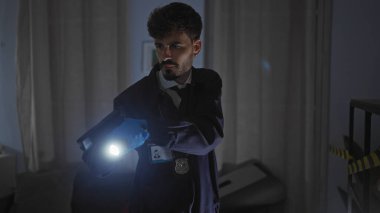 Dedektif, karanlık dairede el feneriyle olay yerini araştırıyor.