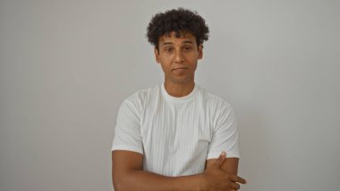 İzole edilmiş beyaz arka planda kendine güvenen bir ifadeyle duran İspanyol genç adam.