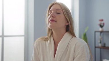 Cübbe giymiş, kaplıcada dinlenen, içi sakin, güneş ışığı pencerelerden süzülen bir kadın.