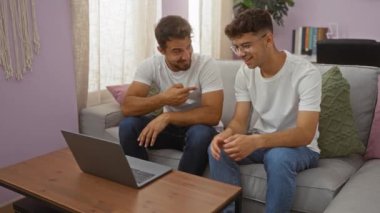 İspanyol baba ve oğlu, oturma odasındaki kanepede aile bağlarını ve bağlarını göstererek Videlicall yapıyorlar.