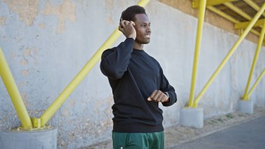 Sıradan pozlarda kulaklık kullanan Afrikalı Amerikalı bir adam..