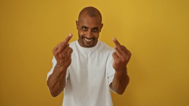 Delikanlı, sarı bir arka plana karşı iki orta parmağıyla müstehcen bir hareket yapıyor. Öfke ya da başkaldırı gösteriyor.