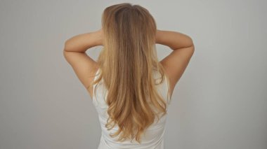 Beyaz bir arka planda, uzun sarı saçlı, yalnız duran, beyaz saçlı genç beyaz bir kadın..