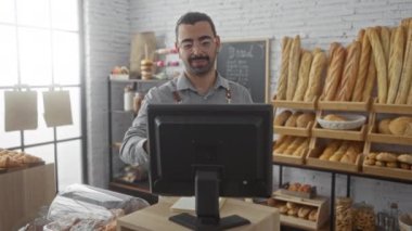 Bir fırında çalışan genç İspanyol bir adam. Etrafı çeşitli zanaatkar ekmek ve hamur işleriyle çevrili.