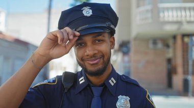 Açık hava ortamında gülümseyen Afrikalı Amerikalı erkek polis.