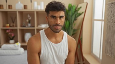 Kaplıcada bitkileri ve dekoru olan yakışıklı bir İspanyol.