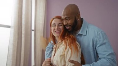 Sıcak bir evin penceresinden bakarken sevgi dolu ırklar arası bir çift oturma odalarında bir neşe ve bağlantı anı yakalıyorlar..