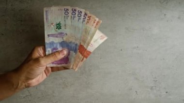 Kolombiya ile ilişkili para birimi, finans ve ekonomik temaları vurgulayan somut bir arka plan karşısında el ele tutuşan Kolombiya pesoları.