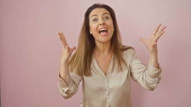 Heyecanlı İspanyol kadın jestleri pembe bir duvara vurgu yapıyor. Duyguları ve canlılığı yansıtıyor..