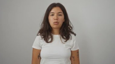 Ayakta duran ve ağzı ve gözleri olan çılgın balık suratı yapan bir kadın. İzole edilmiş arka plan, komik ve eğlenceli ifade üzerine beyaz tişörtlü genç İspanyol kadın.