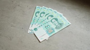 Çin Yuan banknotları, 50 Yuan 'lık mao Zedong portresinin sergilendiği beton bir yüzey üzerine hayran benzeri dizilmiş..