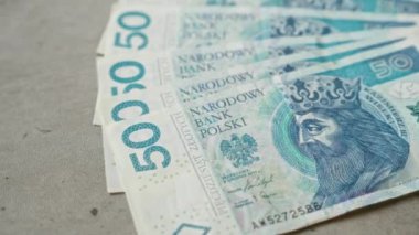 Polonya zloti banknotları beton bir yüzeye yayılmış, görünür narkotik banka polski detaylarıyla sayısız 50 pln banknot sergiliyor..