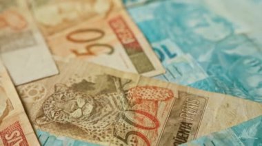 Brezilya 'nın çeşitli banknotları karmaşık tasarımlar ve renkler sergiliyor, Brezilya' nın para birimini detaylı yakın plan görüntülüyor, gerçek para birimlerini vurguluyor..