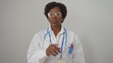 Kıvırcık saçlı ve steteskoplu Afro-Amerikan kadın doktor izole beyaz arka planda sessizliğini koruyor..